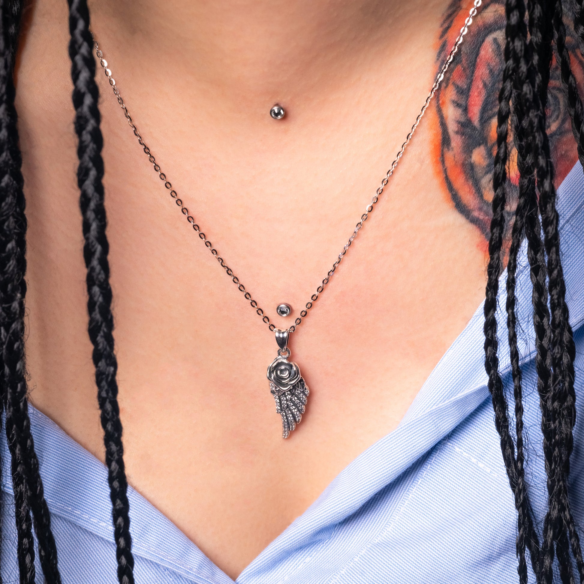 Model wearing Rose Angel Wing Silver Pendant with Flat Cable necklace. Zoomed-in view.