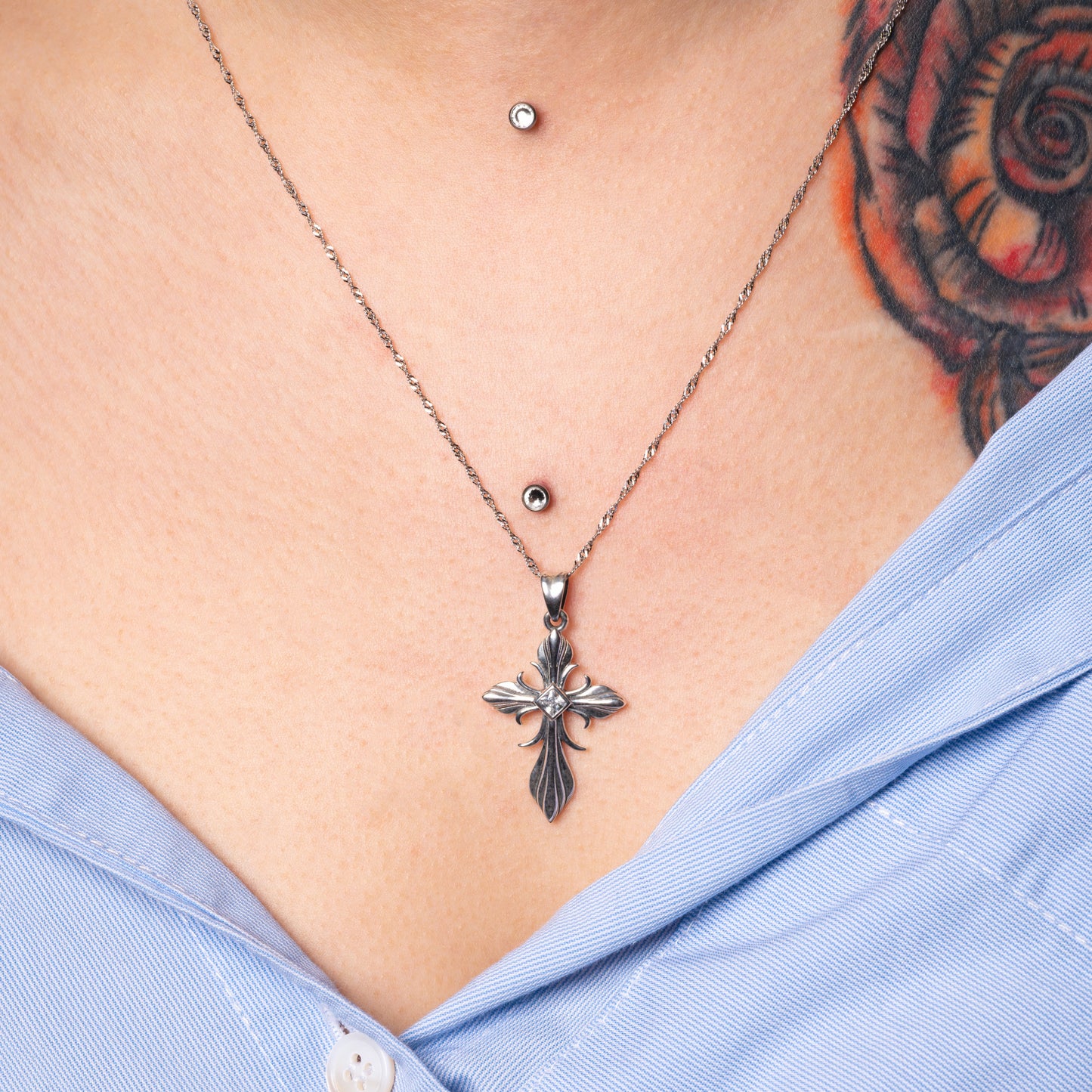 Model wearing Tribal Cross Silver Pendant with Water Wave necklace. Zoomed in.