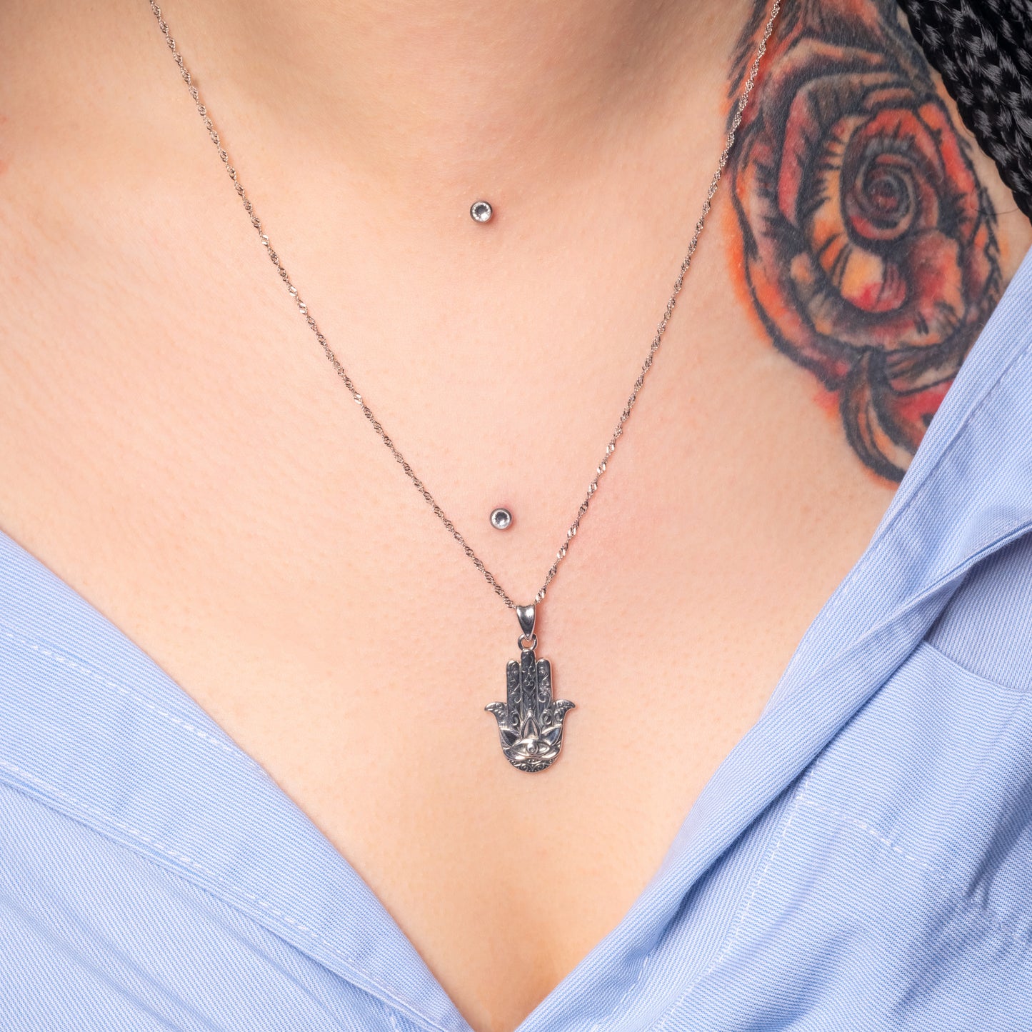 Model wearing Hamsa Hand Silver Pendant paired with Water Wave necklace. Zoomed view.