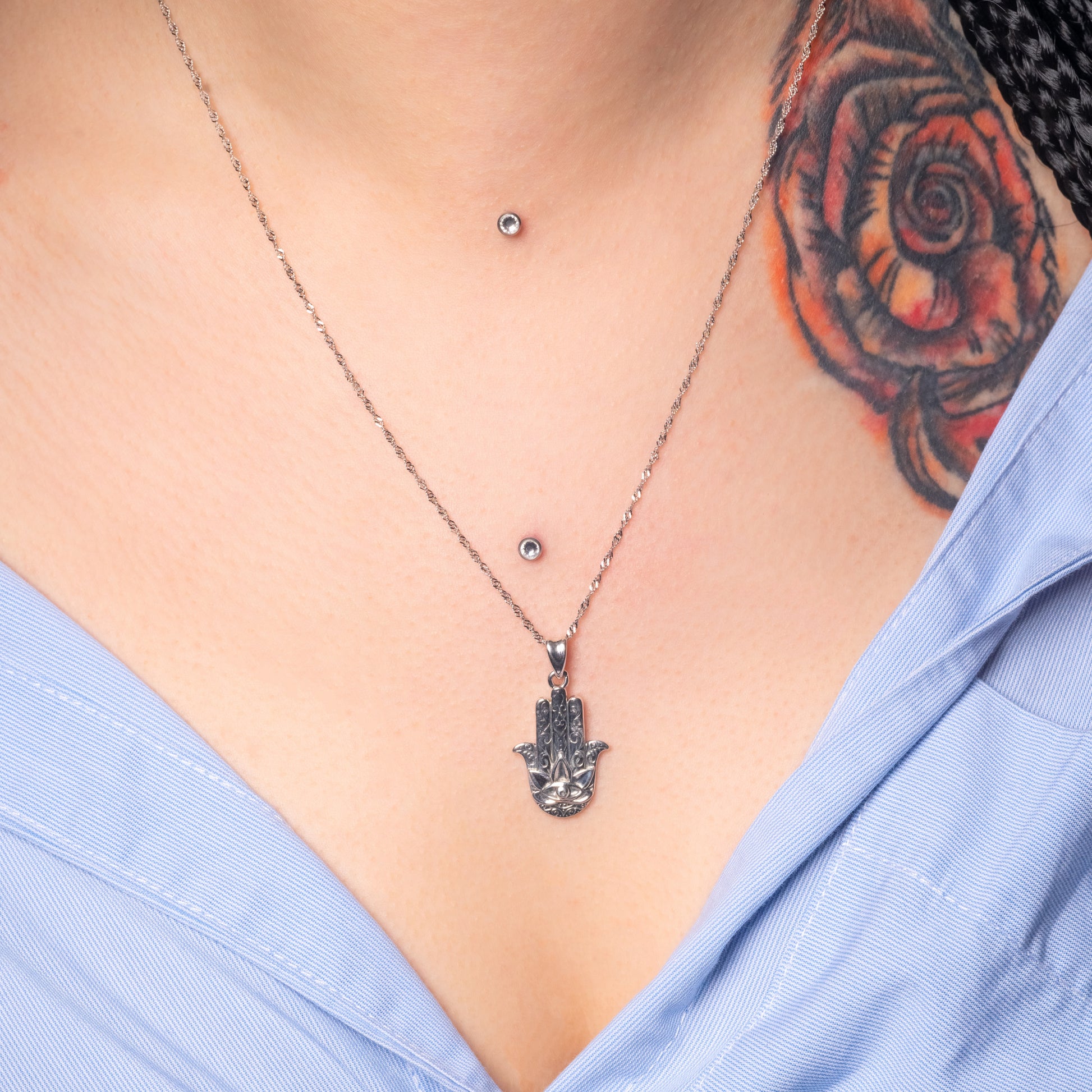 Model wearing Hamsa Hand Silver Pendant paired with Water Wave necklace. Zoomed view.