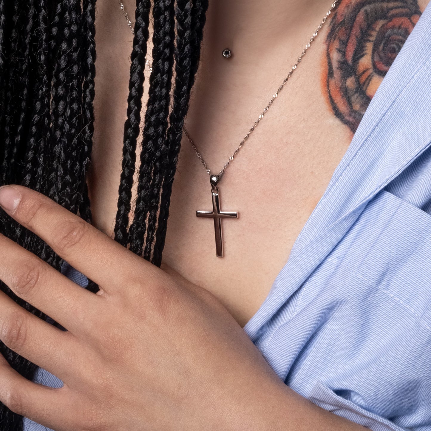 Model wearing Classic Cross Silver Pendant. Zoomed-in