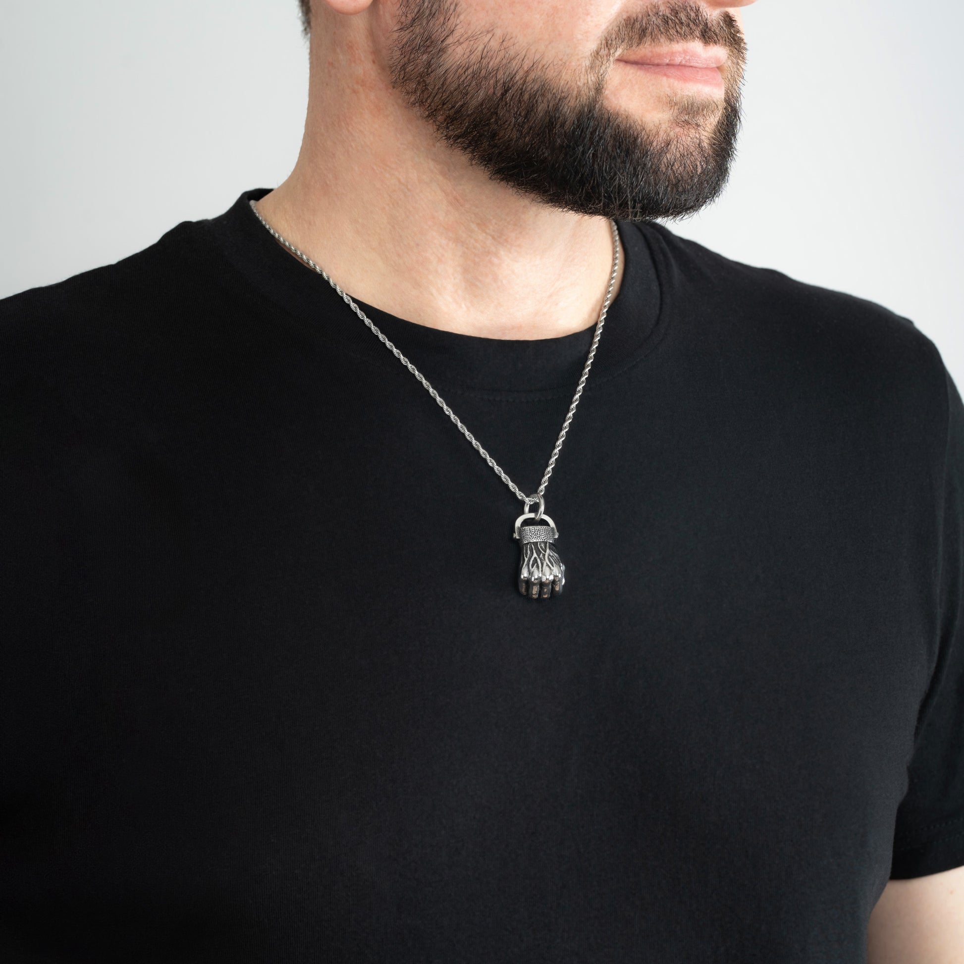 A male model in a black t-shirt wearing a Fist Silver Pendant with a Silver Rope chain 22 inches.