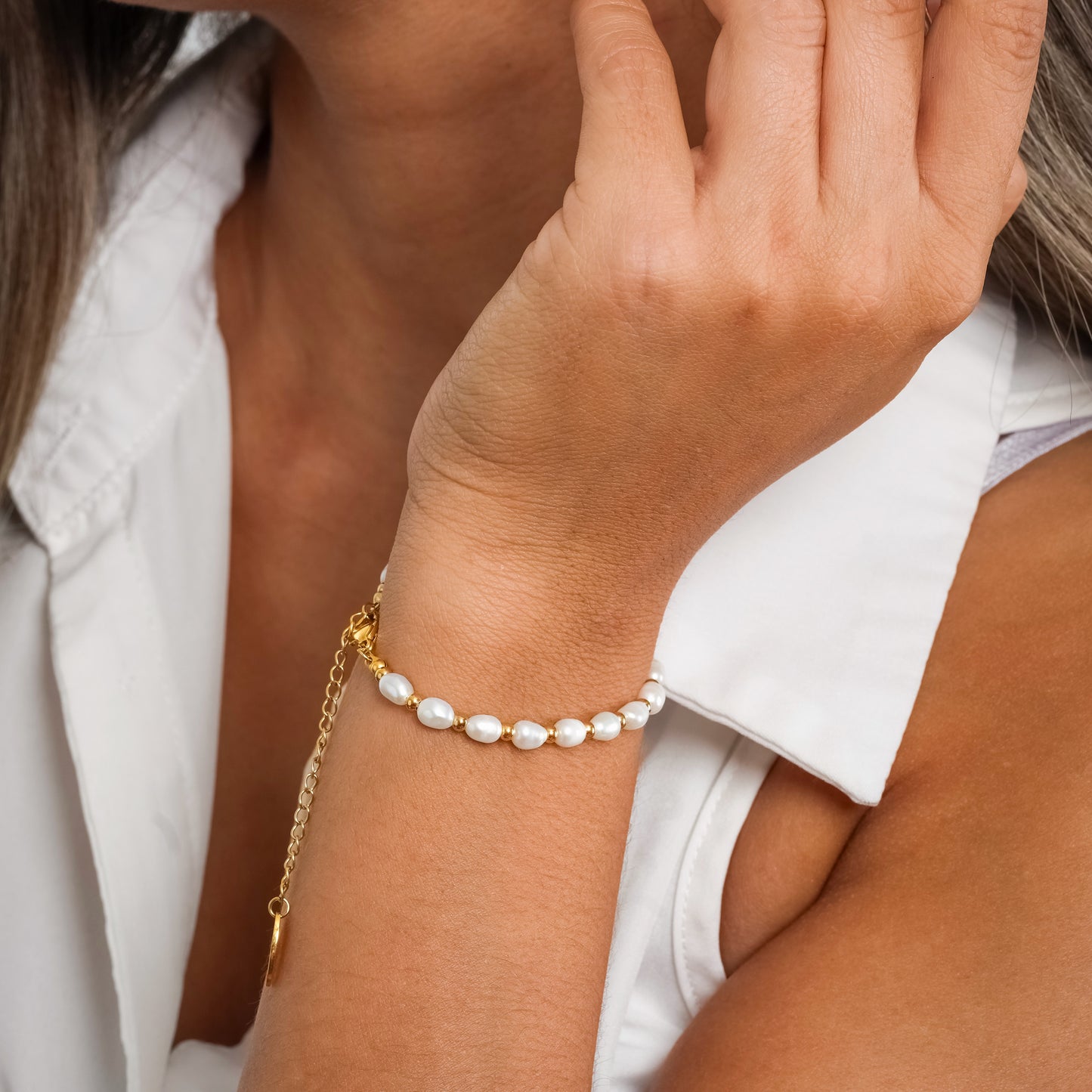 Model in a white sleeveless top wearing Gold Bead Pearl bracelet. Close-up image of the bracelet.