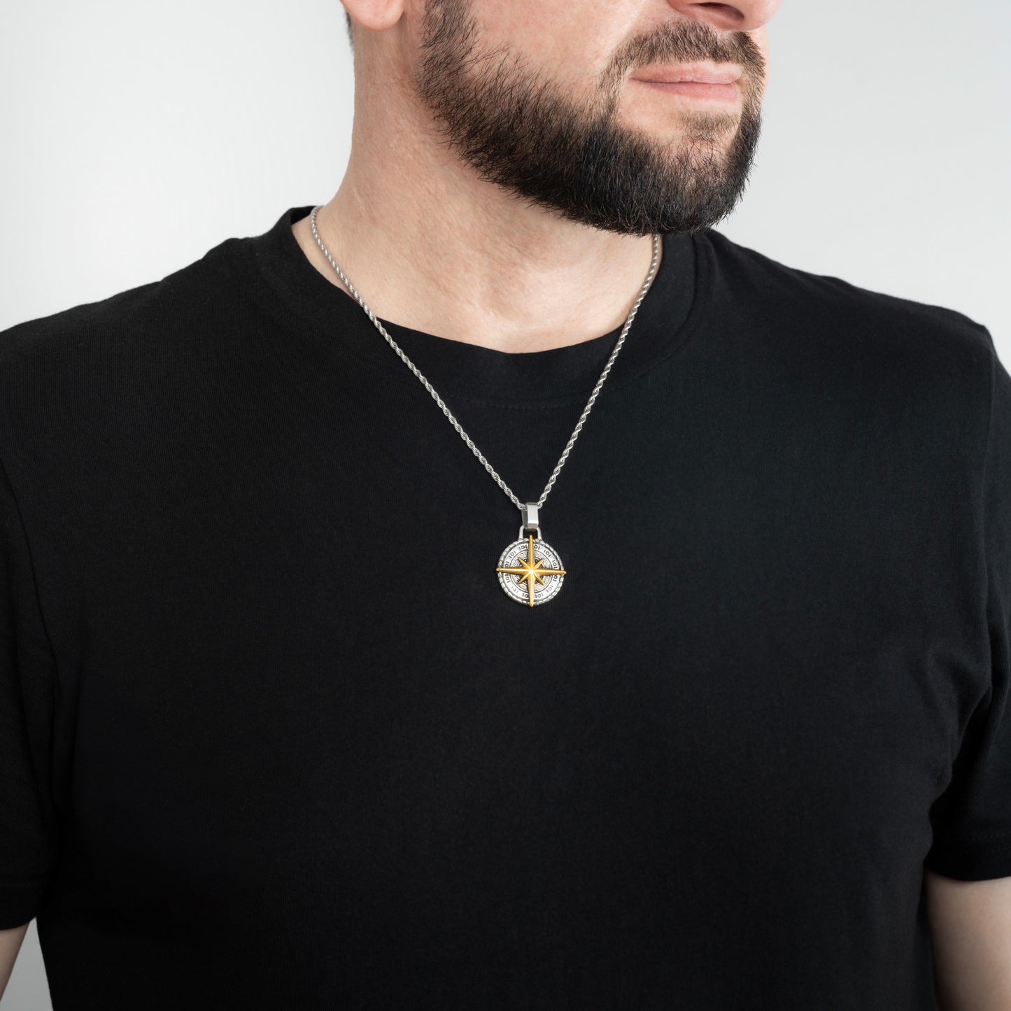 A male model in a black t-shirt wearing a Compass North Star Pendant with a Silver Rope chain 22 inches.