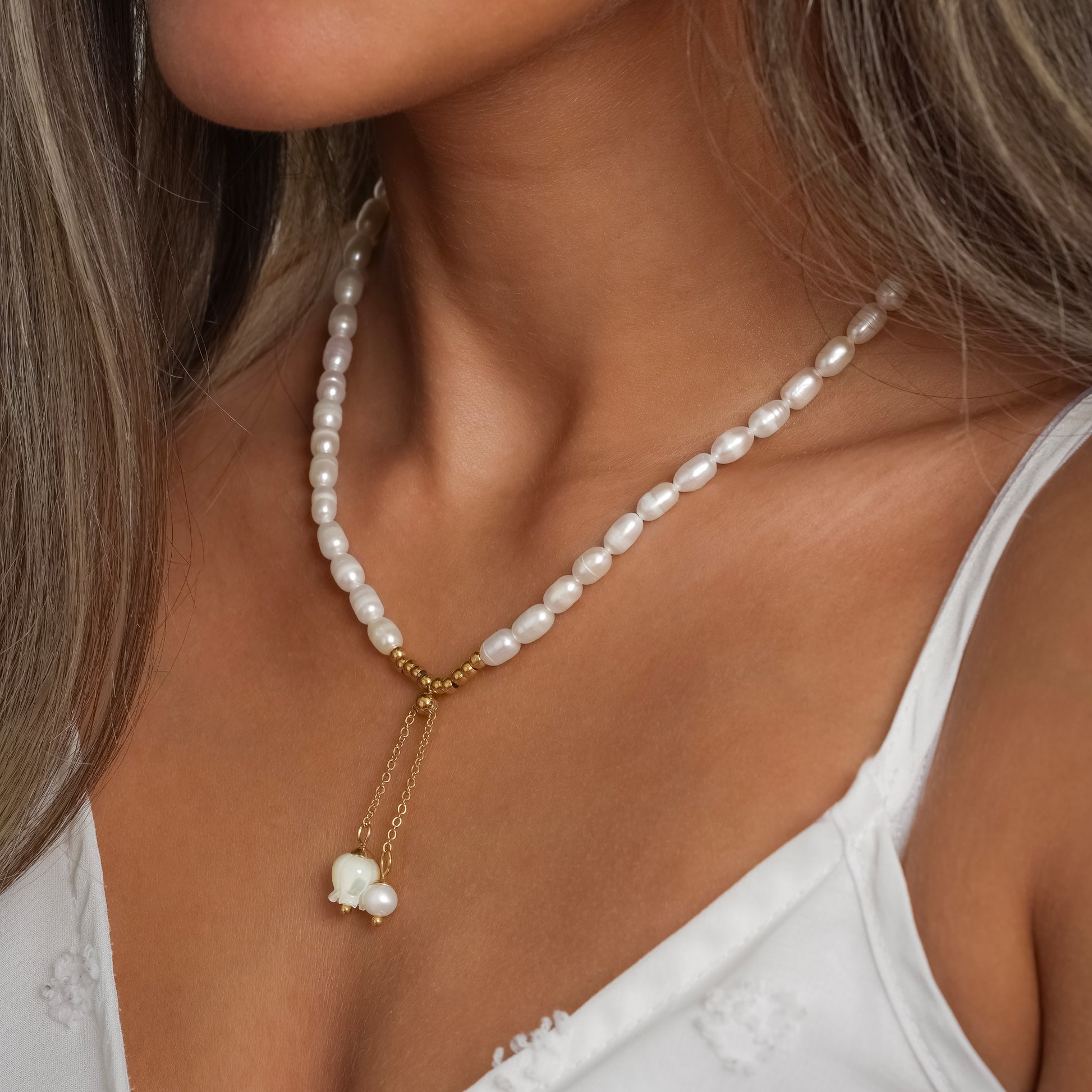 A model in a white dress wearing Lily of the Valley Pearl Necklace