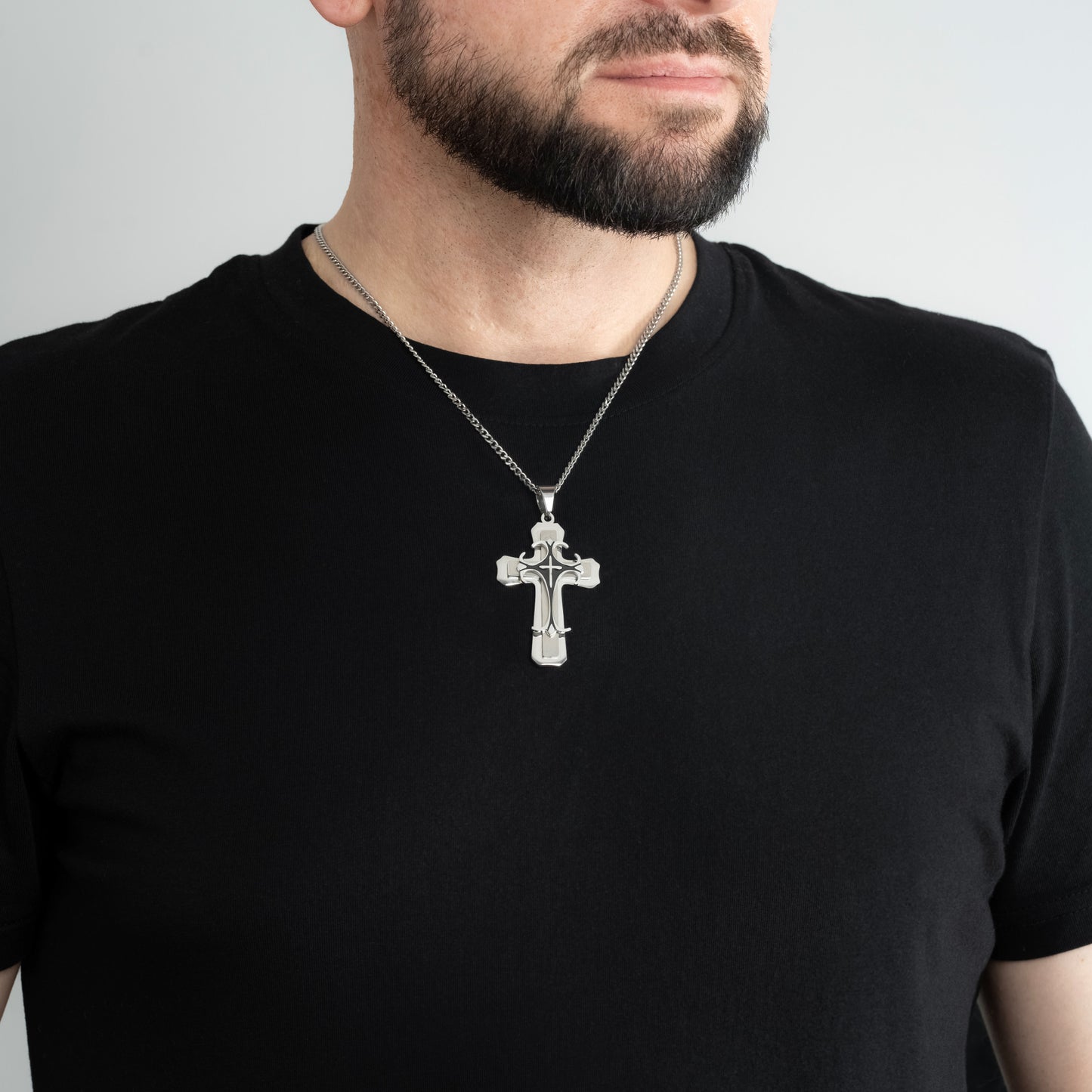 A male model in a black t-shirt wearing a Trinity Cross Pendant with a 3mm Silver Micro Cuban chain 22 inches.