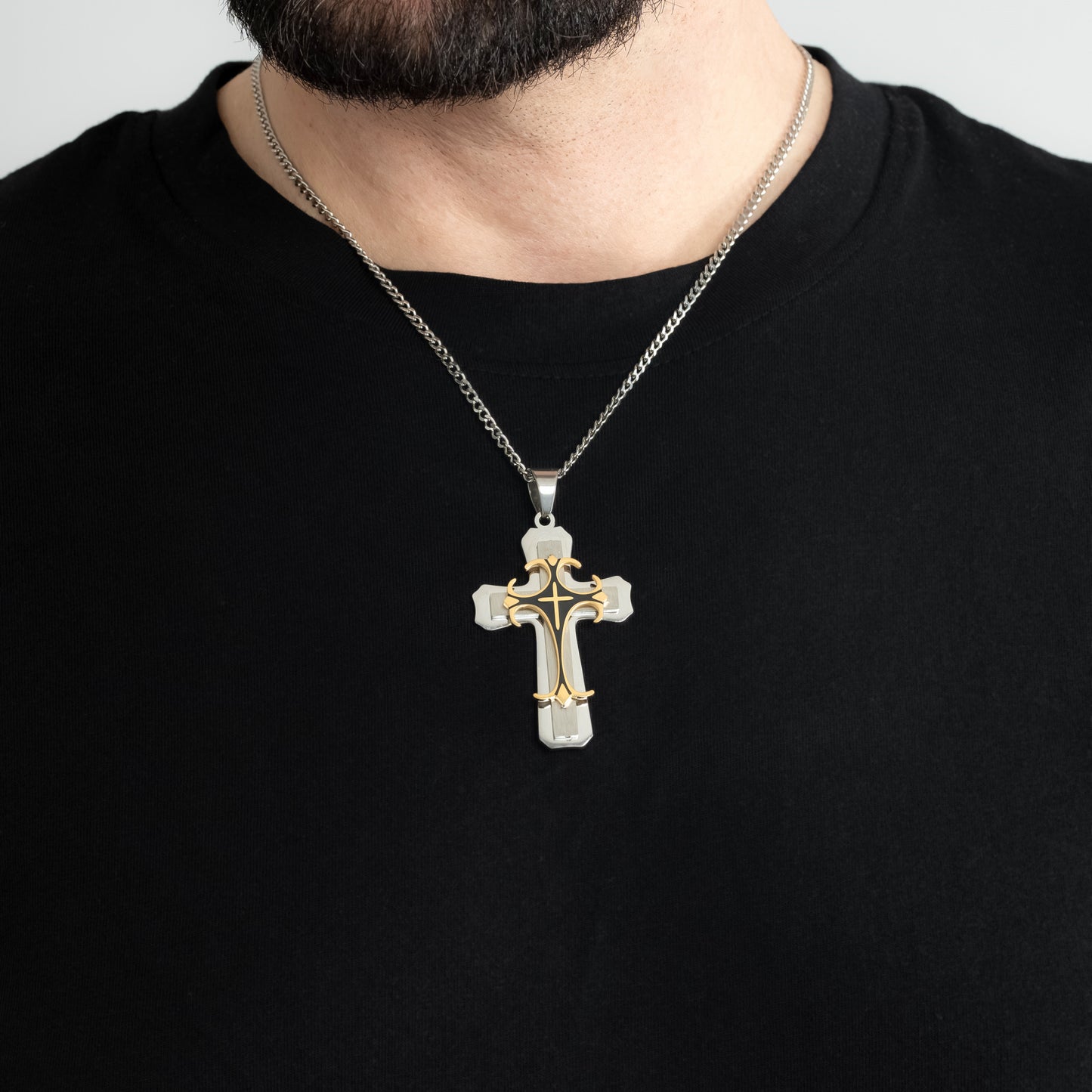 A male model in a black t-shirt wearing a Trinity Cross Pendant with a 3mm Silver Micro Cuban chain 22 inches. Close-up image of the non-tarnish religious men's necklace.