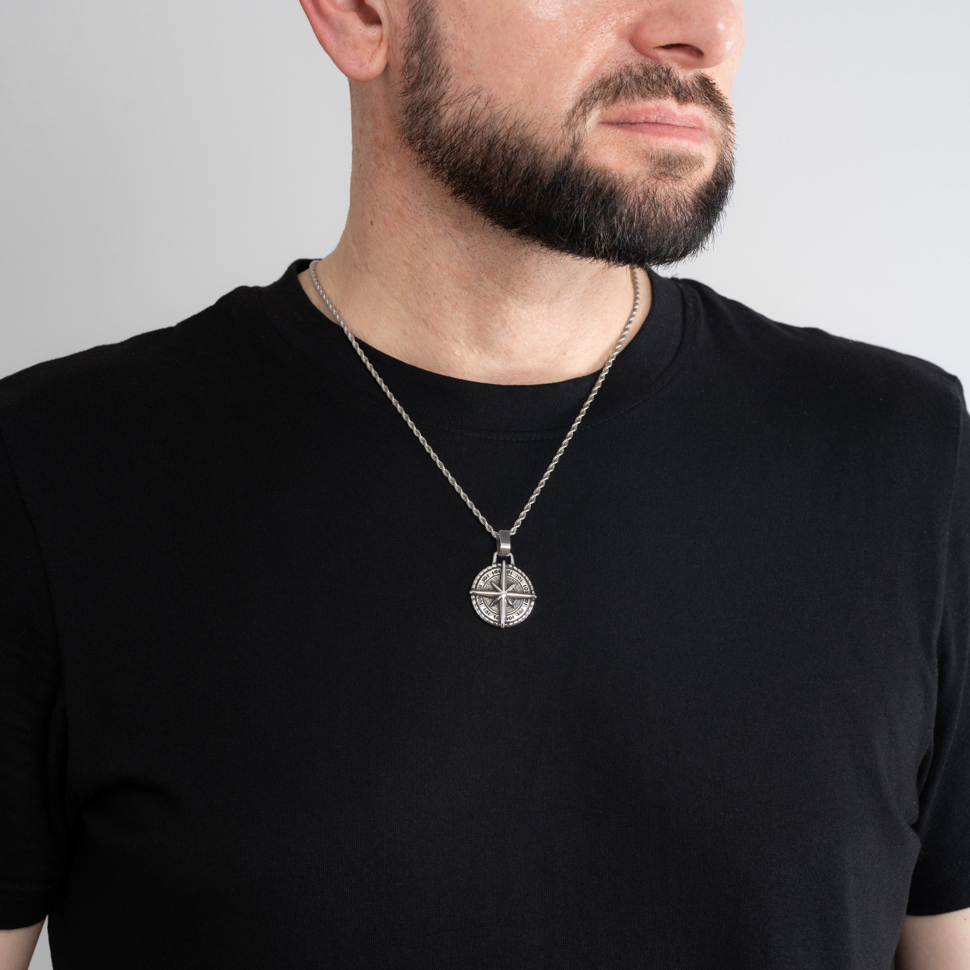 A male model in a black t-shirt wearing a Compass North Star Silver Pendant with a Silver Rope chain 22 inches.