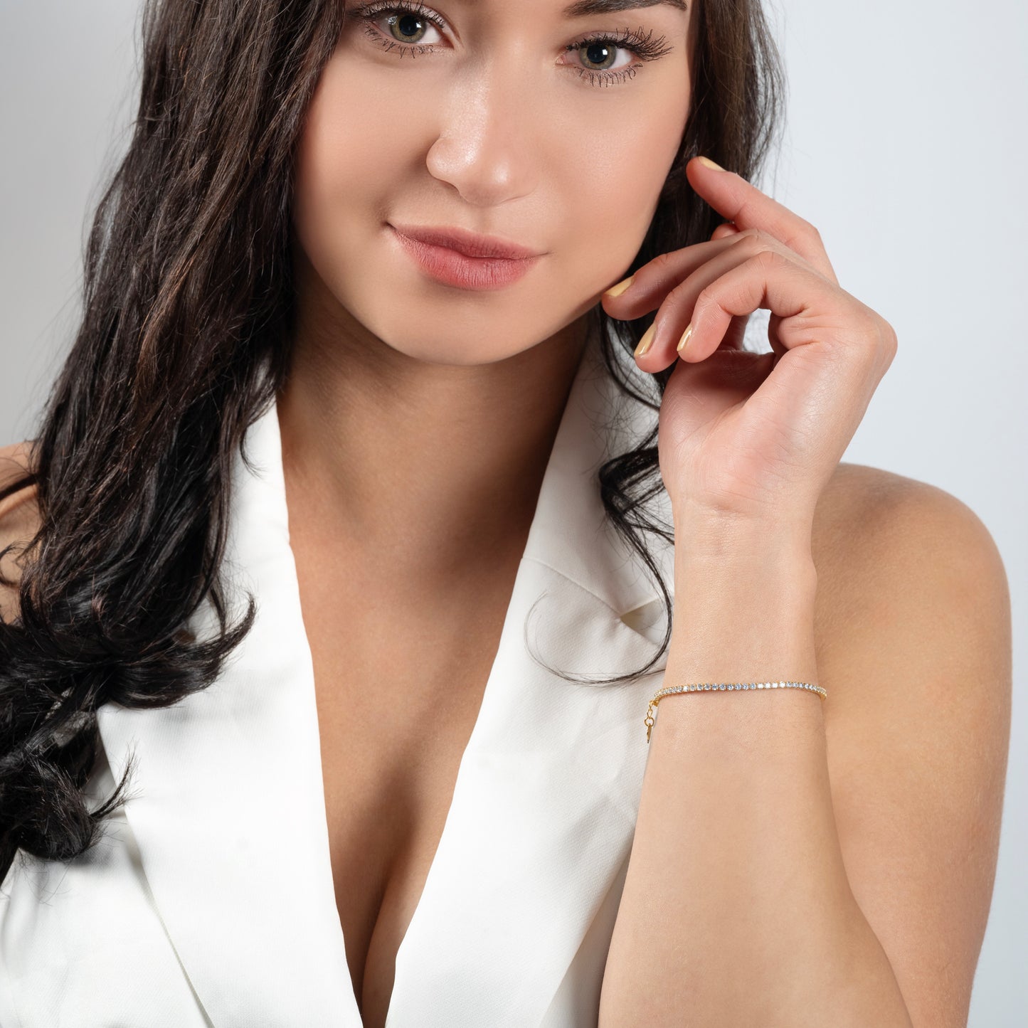 Stunning model with long hair wearing Tennis CZ Gold Bracelet on her hand.