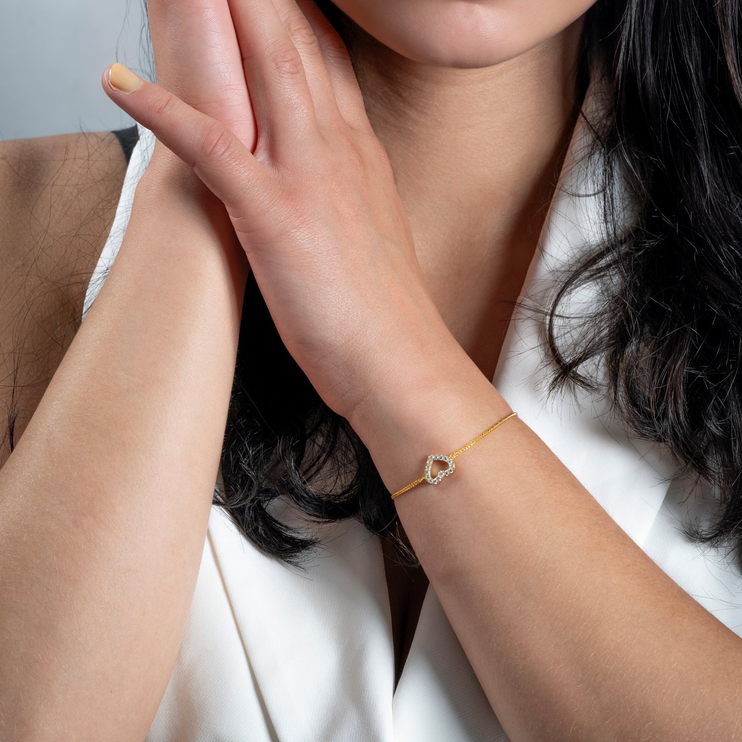 A model in white jacket wearing Love Heart CZ Gold Bracelet on her hand