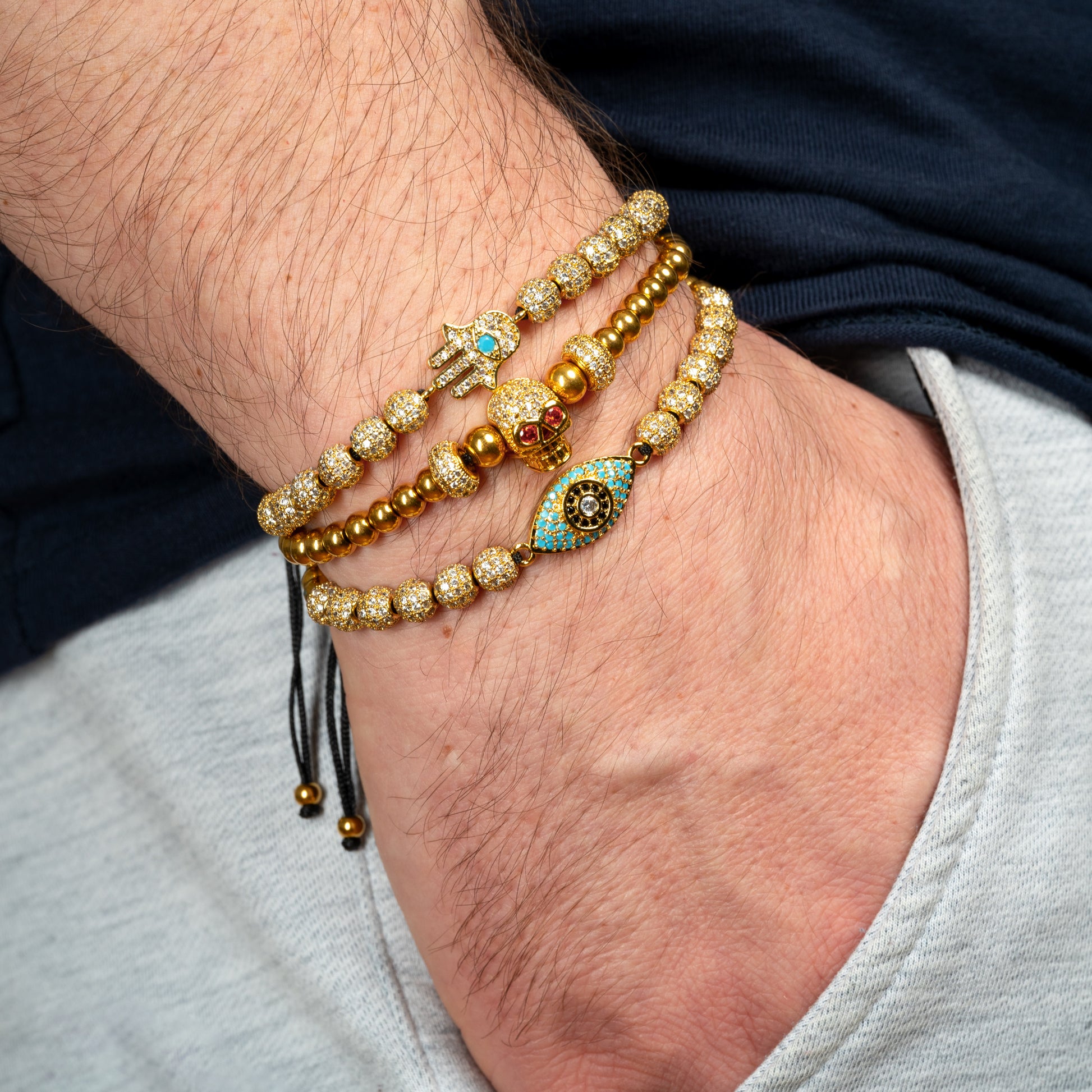 Model wearing Evil Eye Skull Hamsa Bracelet Set on his wrist.