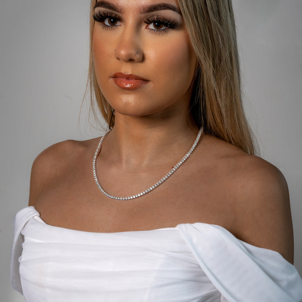 Stunning female model in white dress wearing Cubic Zirconia Tennis Silver Necklace 3mm waterproof and tarnish-free jewellery