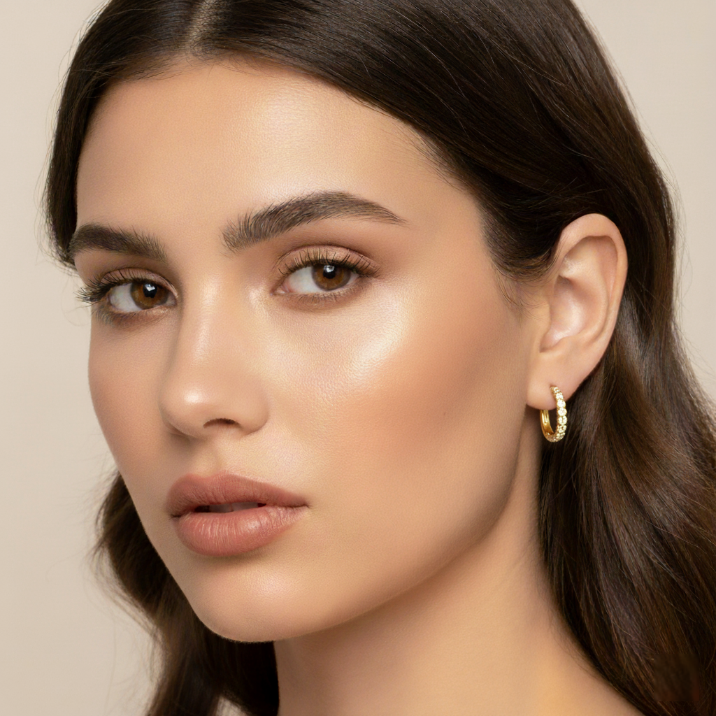 Crysttal 10mm Huggie Hoop CZ Gold Earrings worn on model’s earlobe, showing realistic size, snug fit, and cubic zirconia sparkle in close-up view.