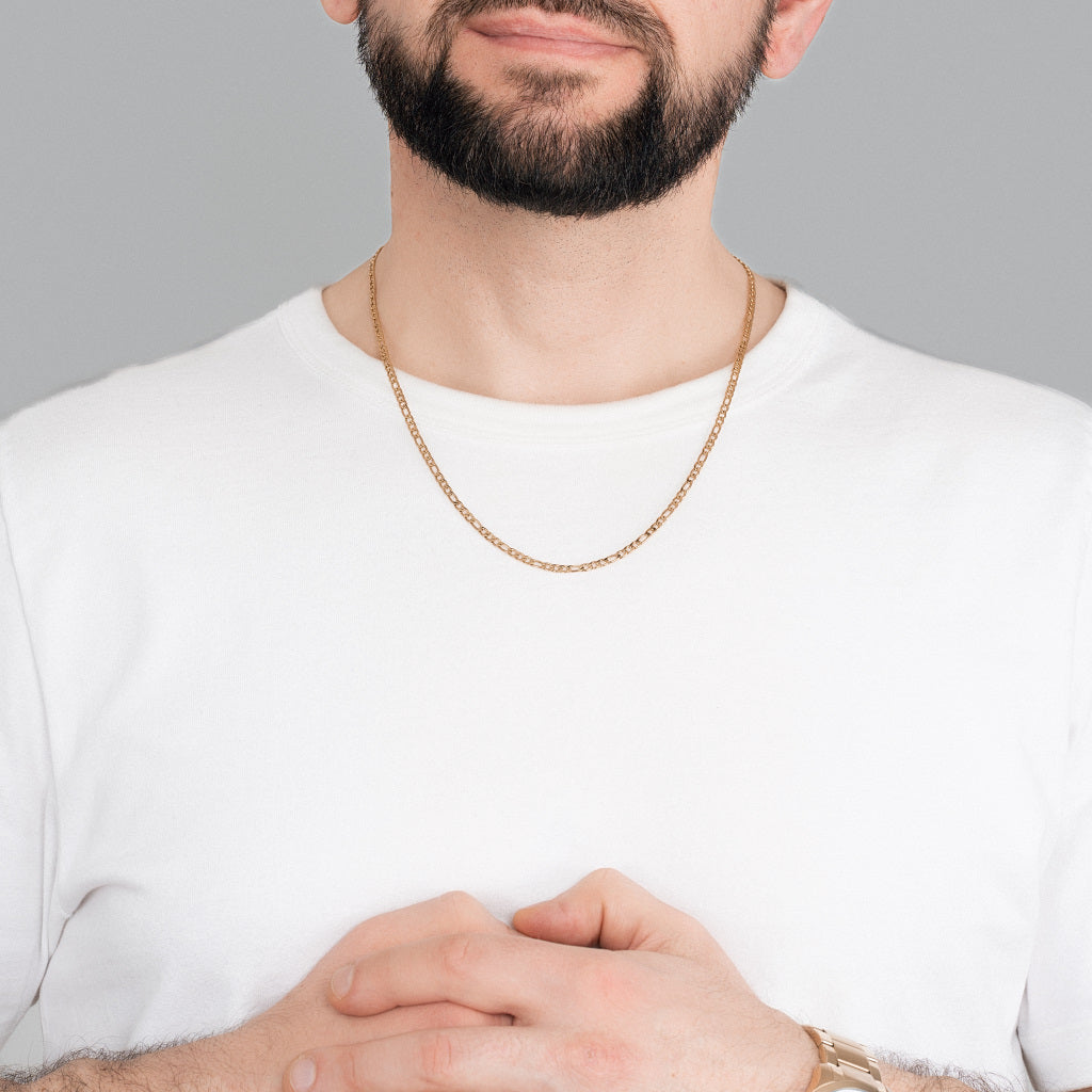 A bearded man in white t-shirt wearing Gold Figaro Chain 3mm, 55cm, and gold watch to match the accessories