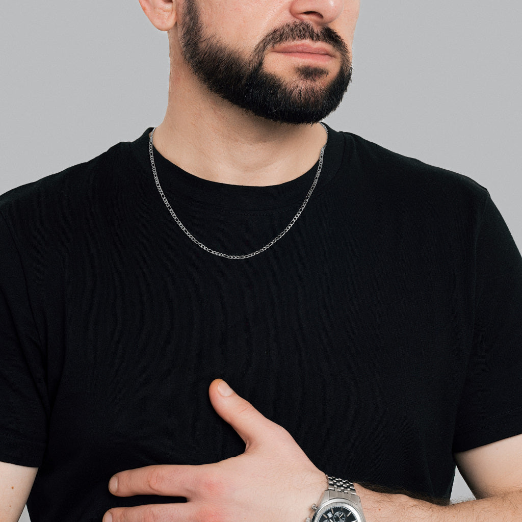 A bearded man in black t-shirt wearing Silver Figaro Link Chain 3mm, 55cm and silver watch to colour match the accessories
