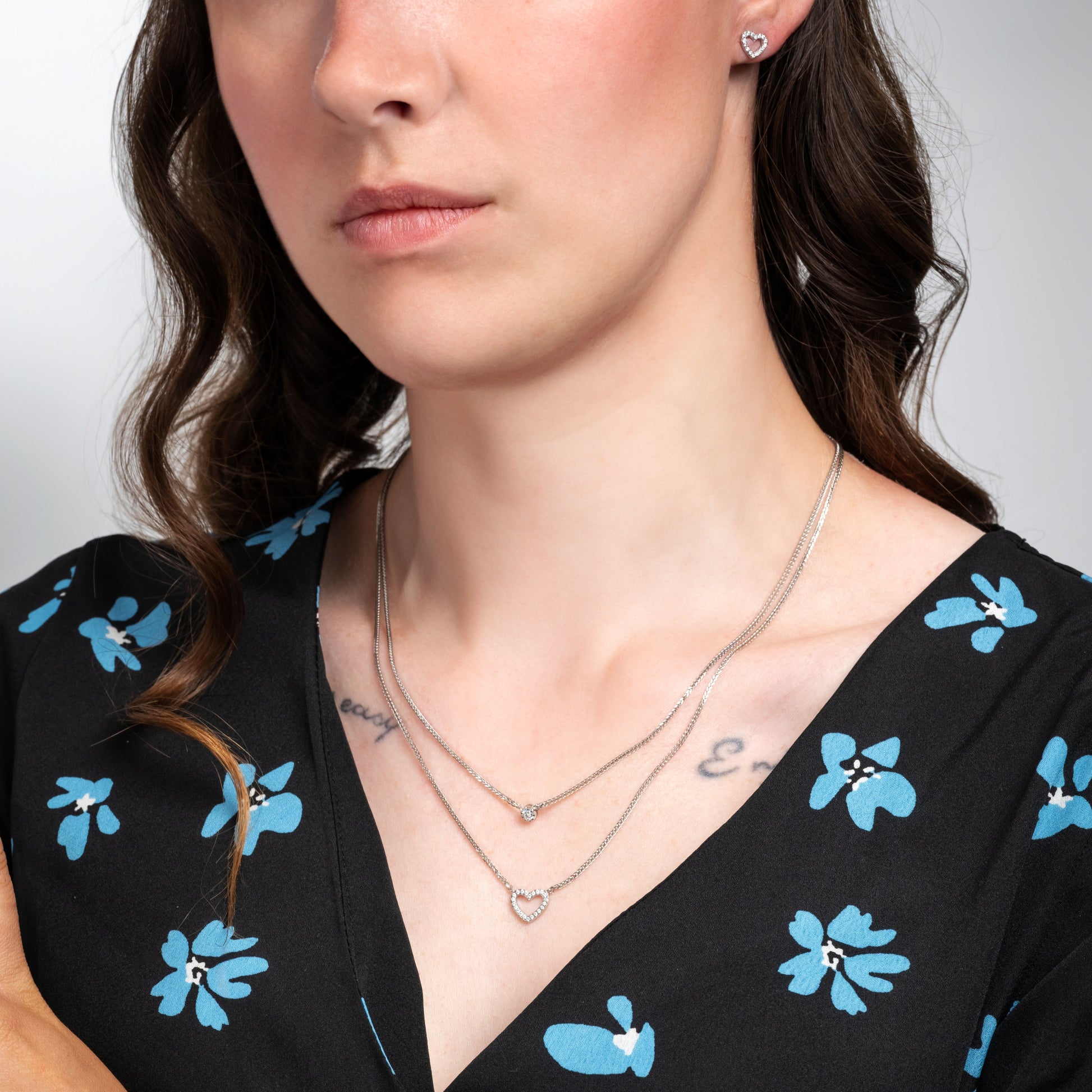 A model wearing Love Heart Earrings Necklace Silver Set