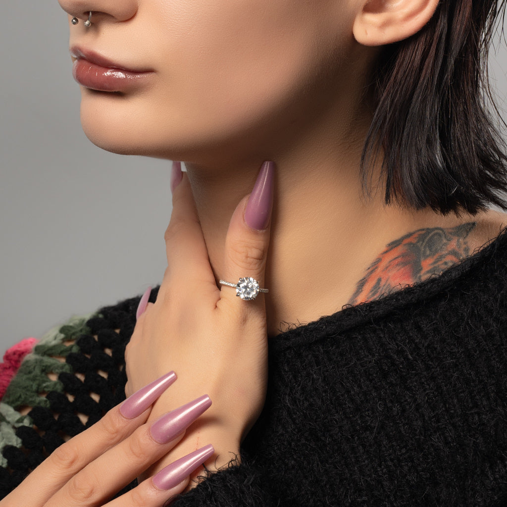 A Tattooed Female Model Wearing Round Cut 5A Cubic Zirconia 925 Sterling Silver Ring on Her Thumb