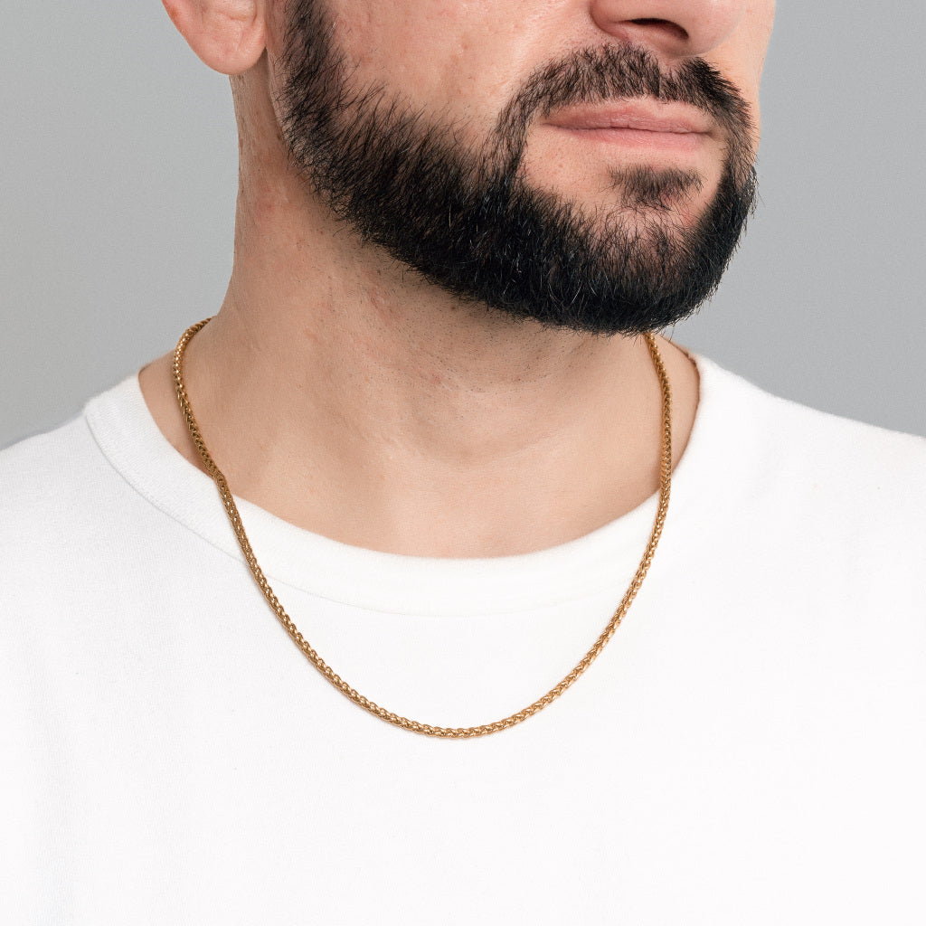 A bearded male model in white t-shirt wearing Gold Spiga Chain 3mm, lifetime men's jewellery
