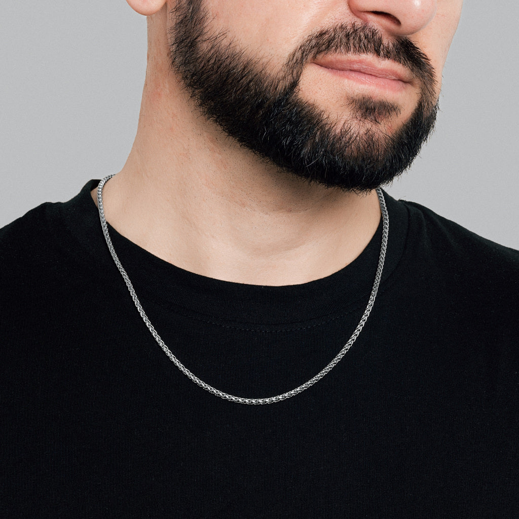 A bearded male model in black t-shirt wearing Silver Spiga Chain 3mm, lifetime men's jewellery