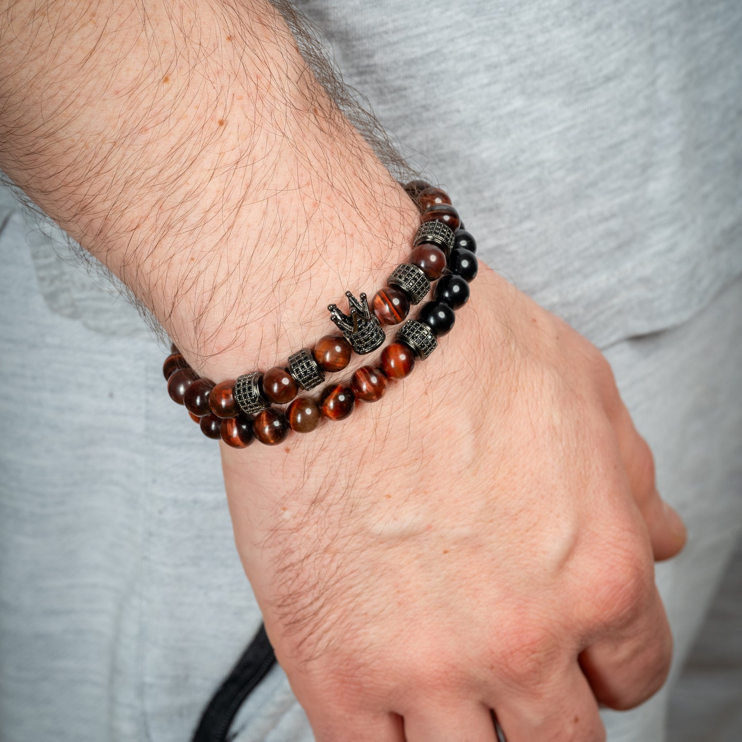 Model wearing Tiger's Eye Black Agate Crown Bracelet Set on his wrist.