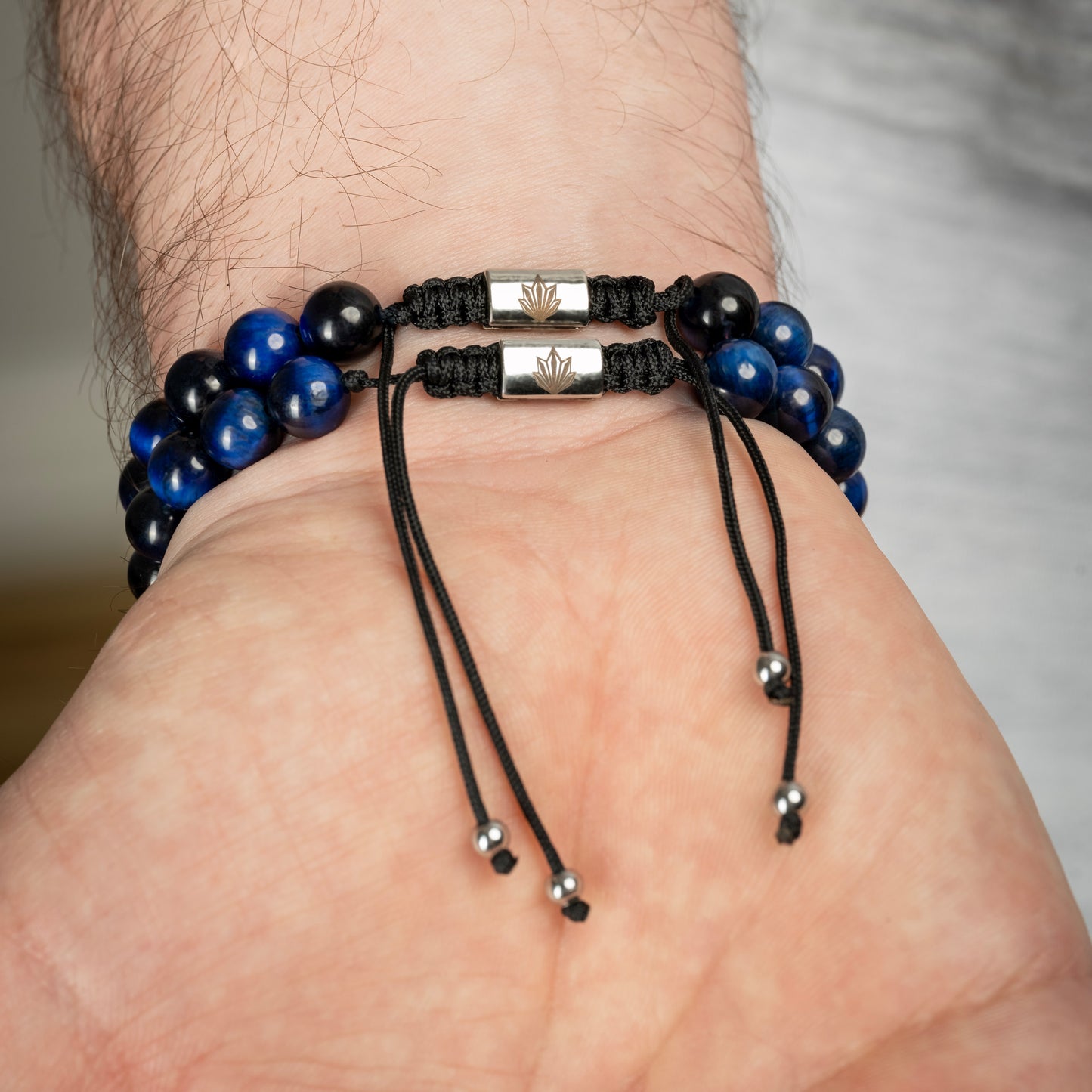 Model wearing Tiger Eye Crown Bracelet Set in blue. Back closure view.