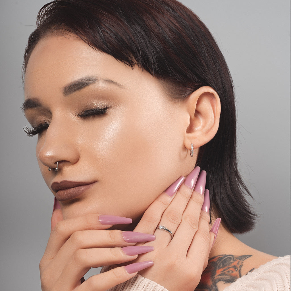 Stunning female model wearing huggie hoop silver earrings with cubic zirconia