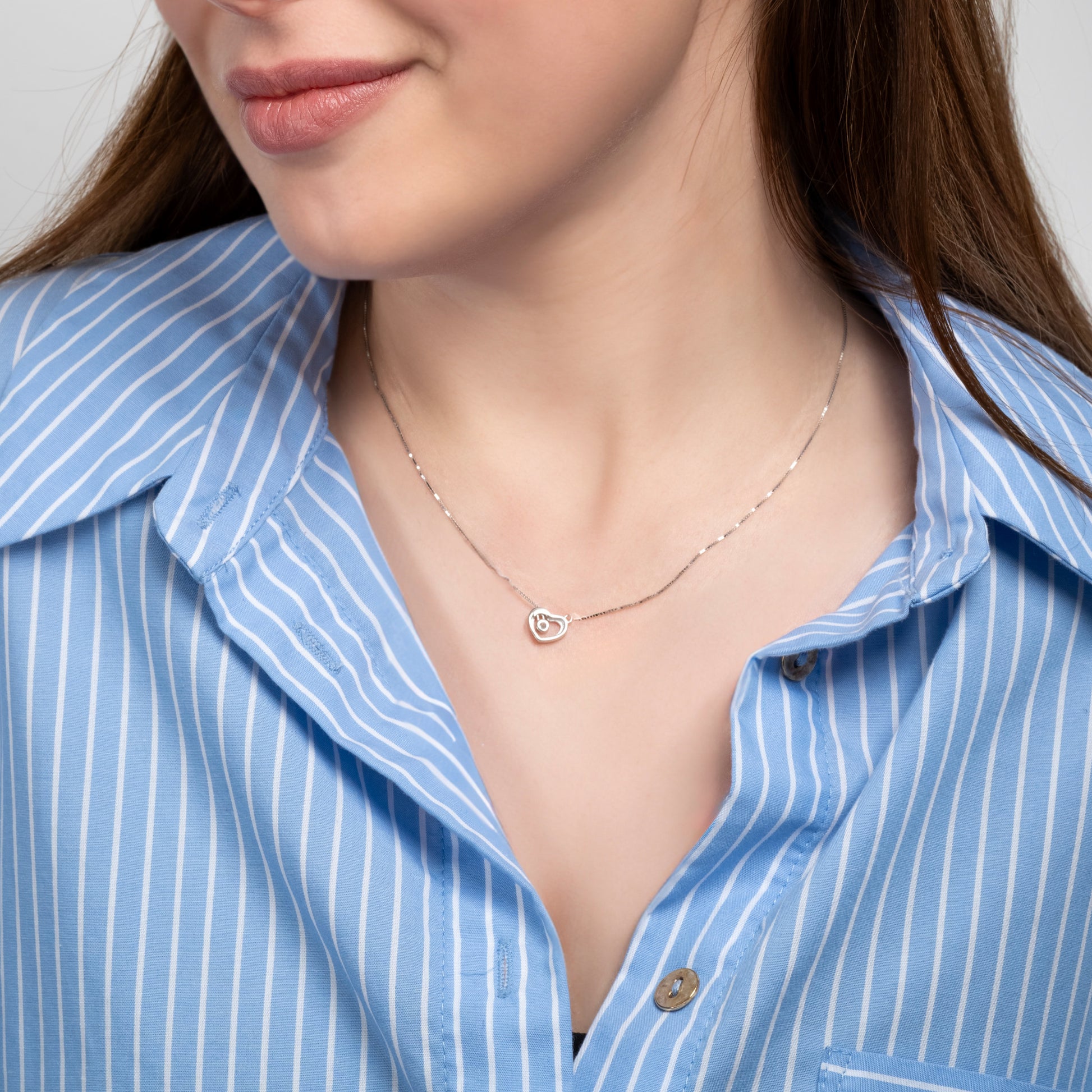 A model in a blue shirt wearing Heart Shape Silver Necklace