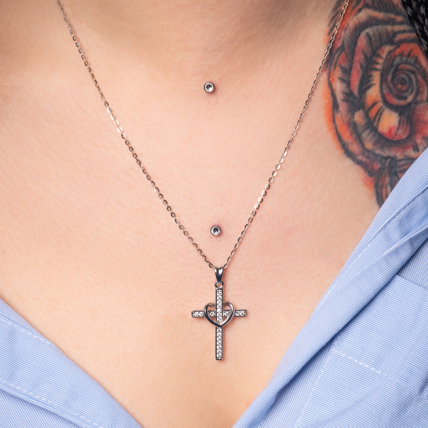 Model wearing Cross and Heart Silver Pendant with Flat cable necklace. Zoomed view.