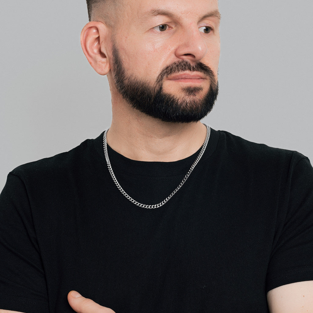 A bearded male model in black t-shirt wearing Silver Miami Cuban Chain 5 mm, statement, lifetime, stainless steel, non-tarnish, waterproof men's jewellery