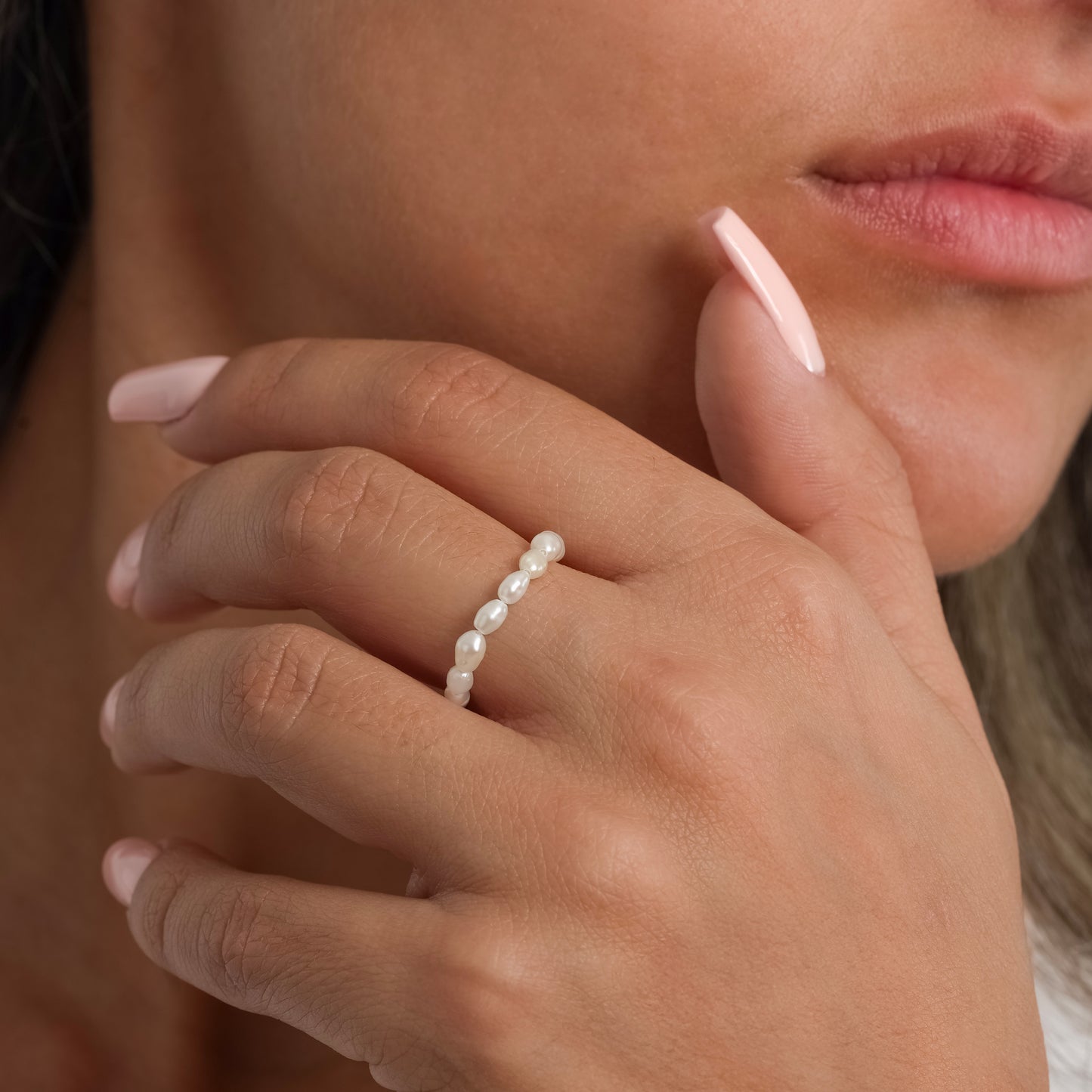 A model in a white sleeveless top wearing Freshwater Pearl ring on her finger. Close-up image of the ring.