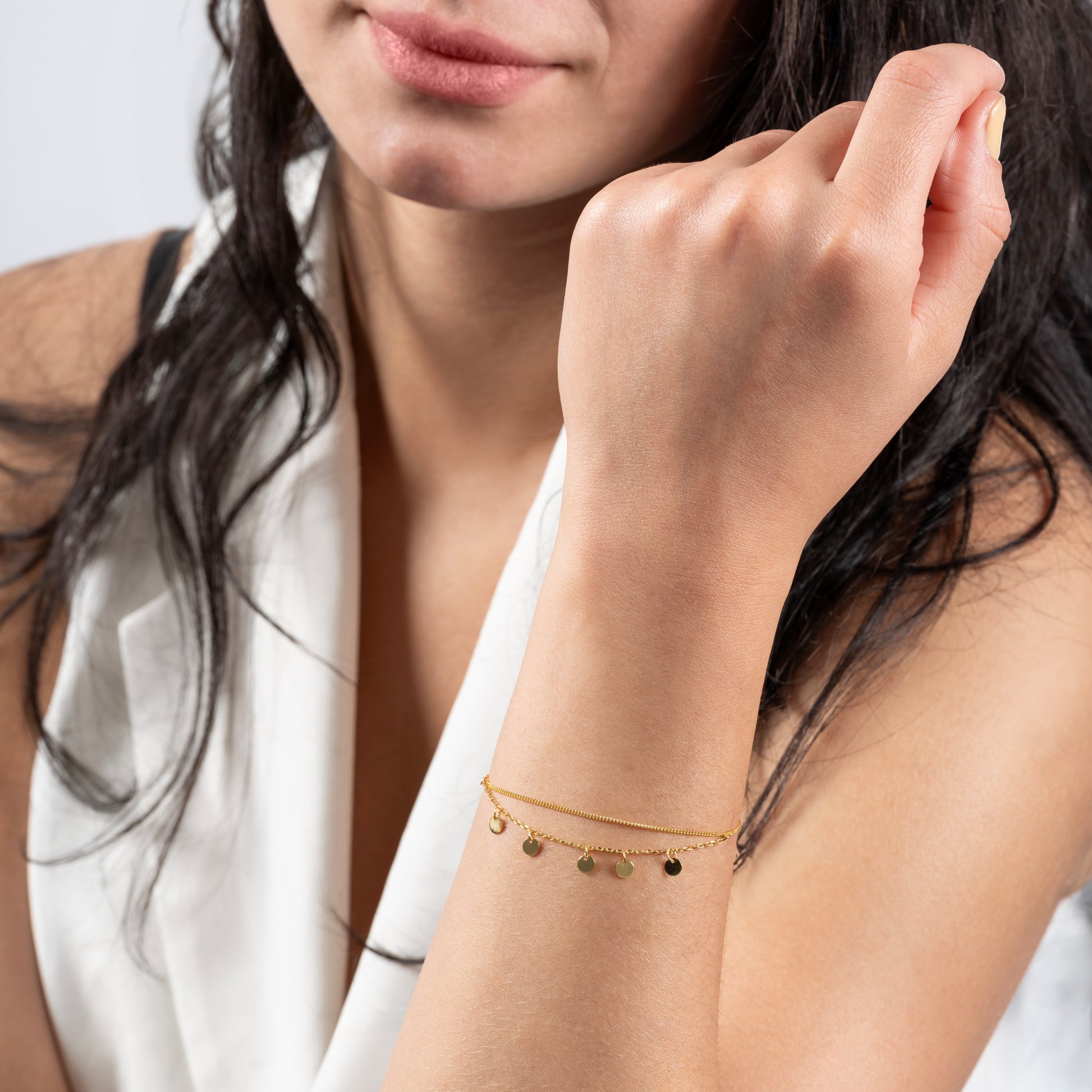 A model wearing Disc Pendant Gold Bracelet on her hand.