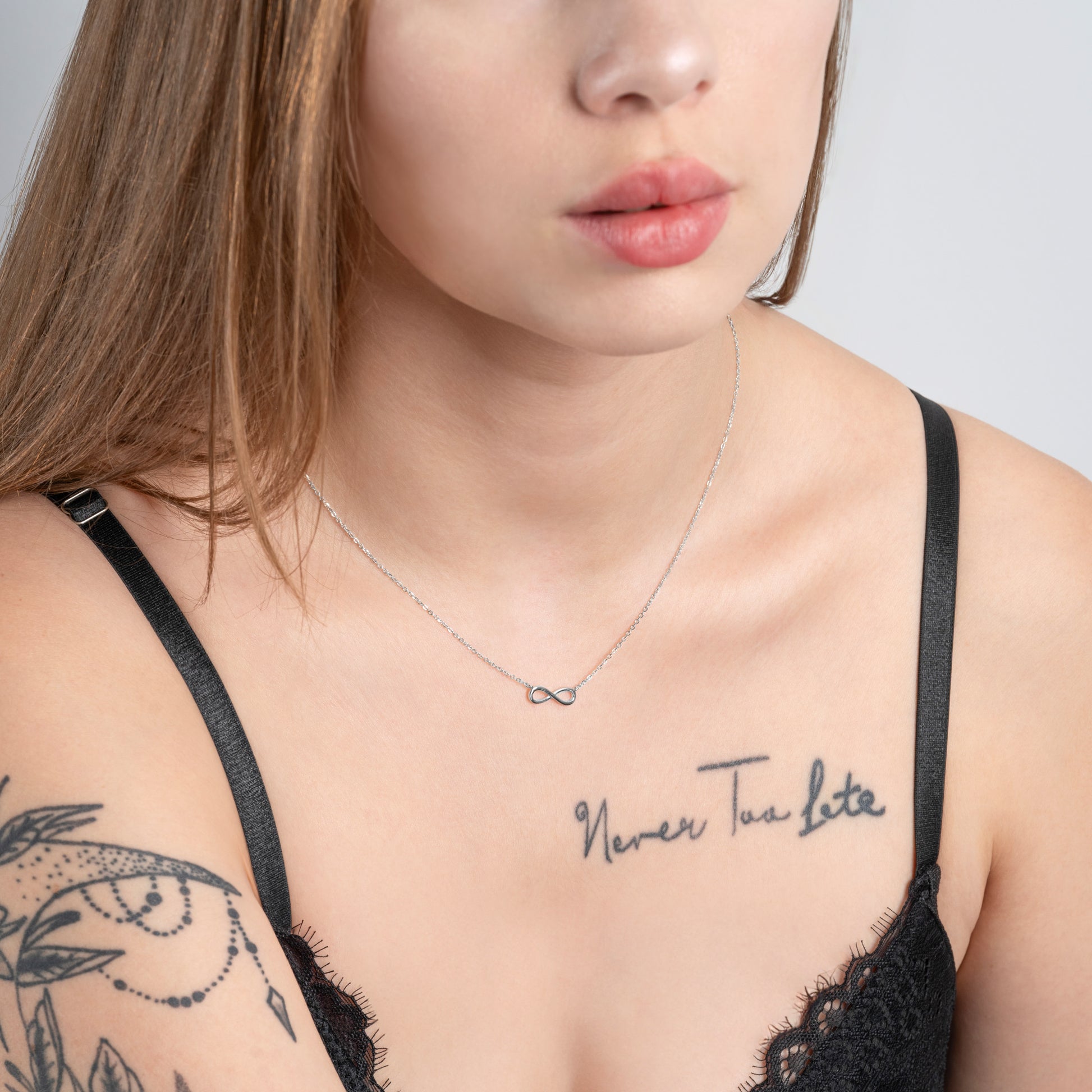 Tattooed model wearing Infinity Silver Necklace on her neck.