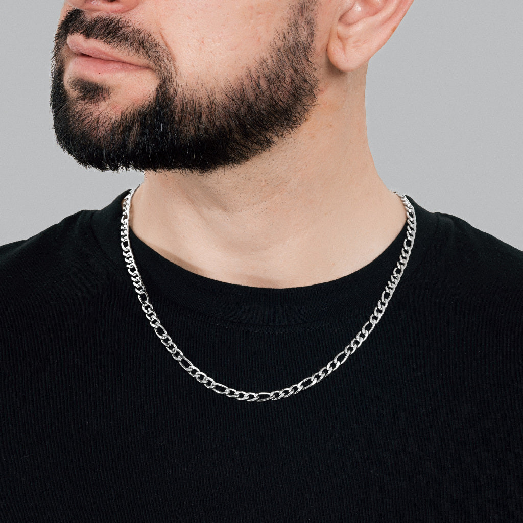 A bearded male model in black t-shirt wearing Silver Figaro Link Chain 5 mm, statement, lifetime, stainless steel men's jewellery