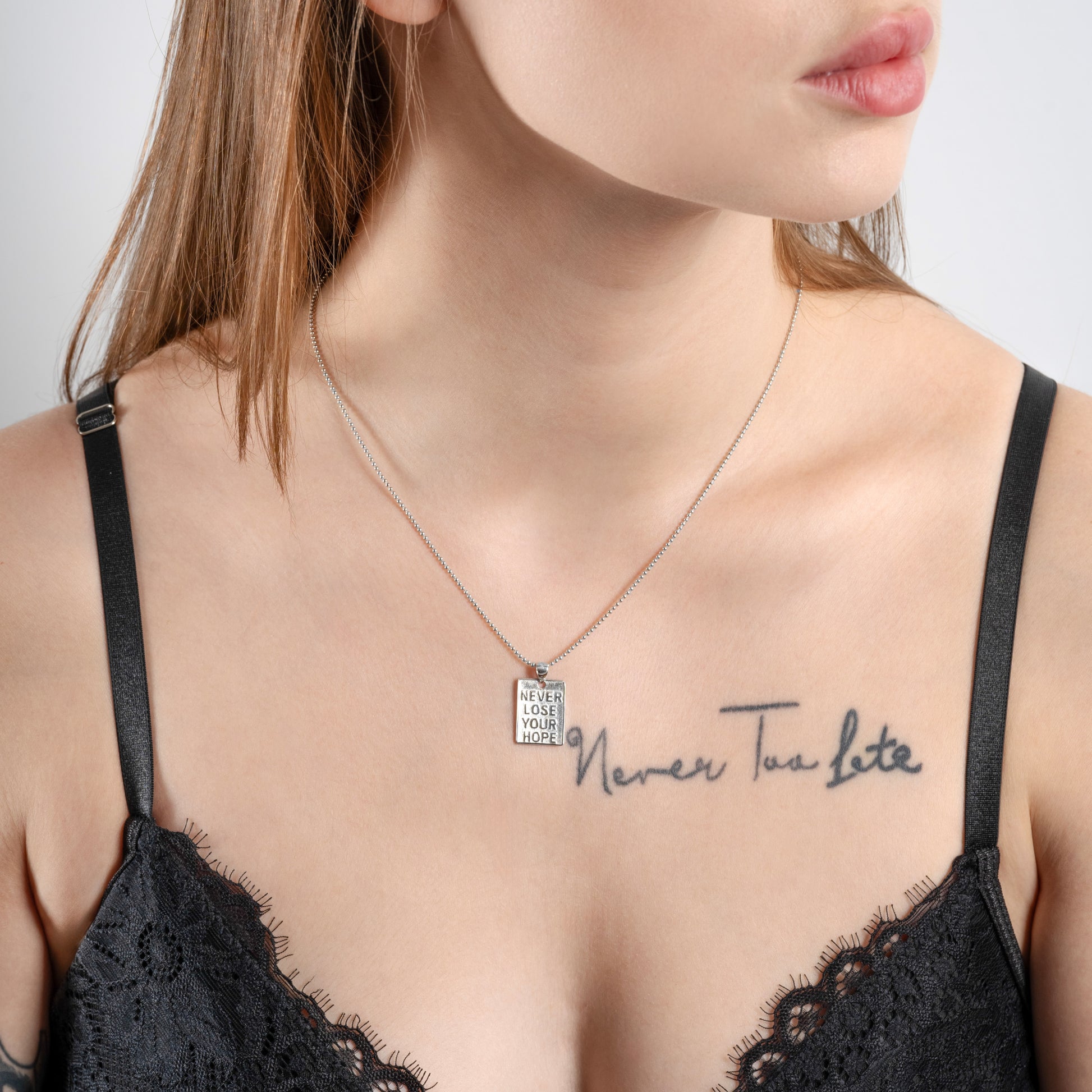 Tattooed women wearing Never Lose Your Hope Motivational Silver Necklace on her neck